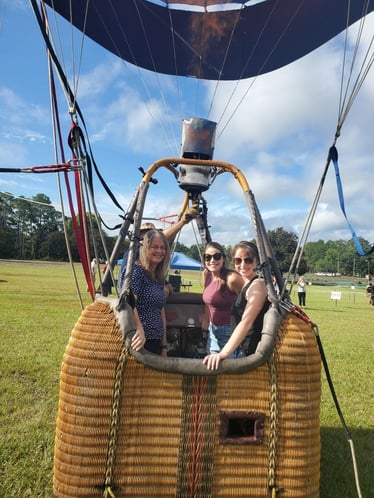 three women in a hot air balloon. 